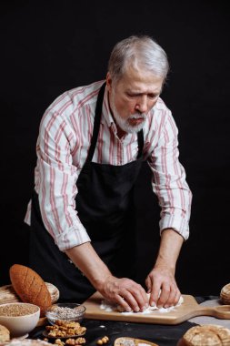 Olgun baker adam masada ekmek hamur yoğurma sakallı
