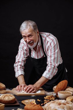 Olgun baker adam masada ekmek hamur yoğurma sakallı
