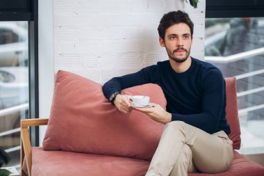 Genç iyi görünümlü ofis çalışanı ile bir fincan çay dinleniyor