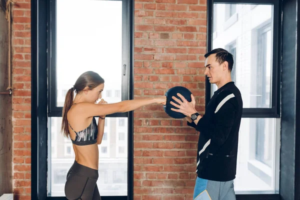 Joven divertida chica está utilizando una bola como un saco de boxeo — Foto de Stock