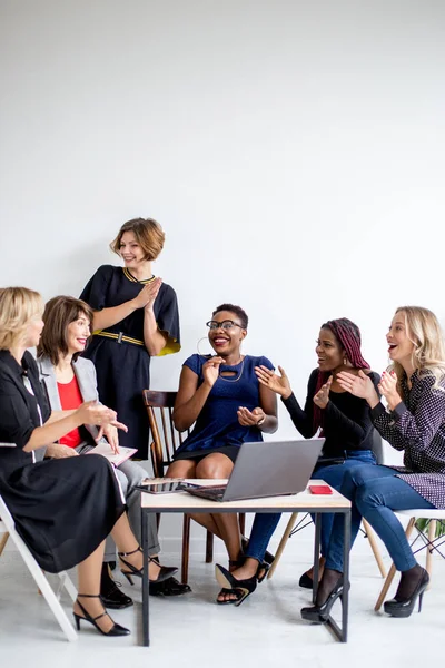 Pozitív nők megvitatják a szervezési tervet, miközben ül az asztalnál laptop — Stock Fotó