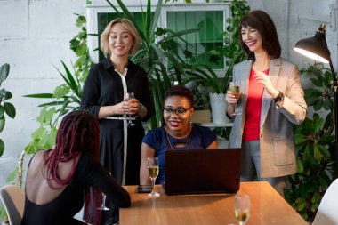 Portrait of female business team in modern studio with glasses of champagne. clipart