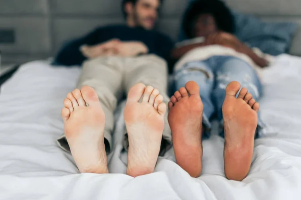 Primo piano di piedi di coppia interrazziale dormire insieme. — Foto Stock