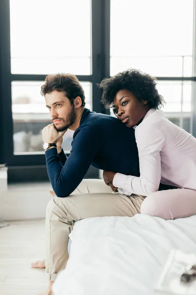 Interracial young couple relaxing and having fun on bed. African woman