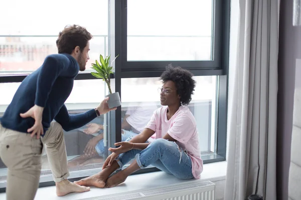 Romantisch gemengd ras paar staan bij het raam denken over hun toekomst. — Stockfoto