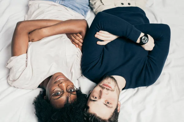 Ritratto di coppia felice, vestito con disinvoltura, sdraiato sul letto in camera da letto — Foto Stock