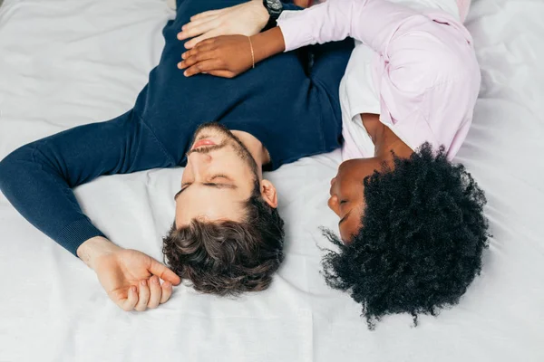 Pareja joven durmiendo juntos en la cama en el dormitorio, abrazándose dulcemente —  Fotos de Stock