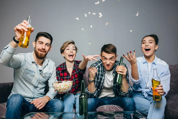 Un grupo de jóvenes con una botella de cerveza animando a su equipo favorito — Foto de Stock