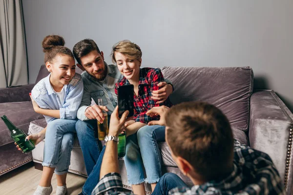 Amigos felices tomando fotos mientras beben cerveza en casa — Foto de Stock