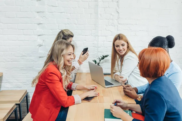 Mujeres jóvenes hacen equipo con amigos independientes y crean un pequeño club de coworking. —  Fotos de Stock