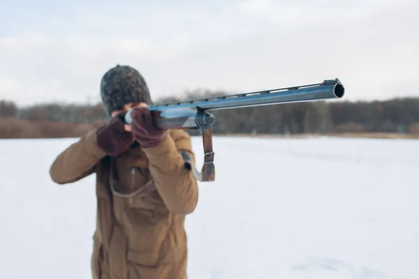 Man håller ett gevär. killen som fotograferar med en lång pistol — Stockfoto