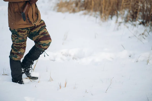 Man with a gun is walking on a snowy field Royalty Free Stock Photos