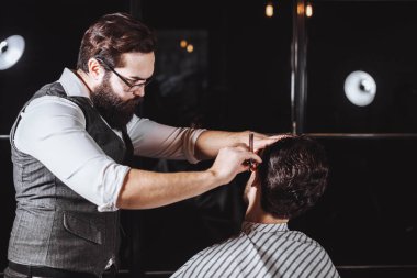Yetenekli berber. Genç adam jiletle eski moda tıraş oluyor.