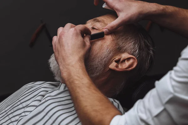 Vecchio ottenere la sua barba rasata dal barbiere — Foto Stock