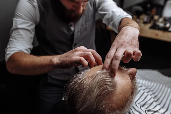 Vecchio ottenere la sua barba rasata dal barbiere — Foto Stock