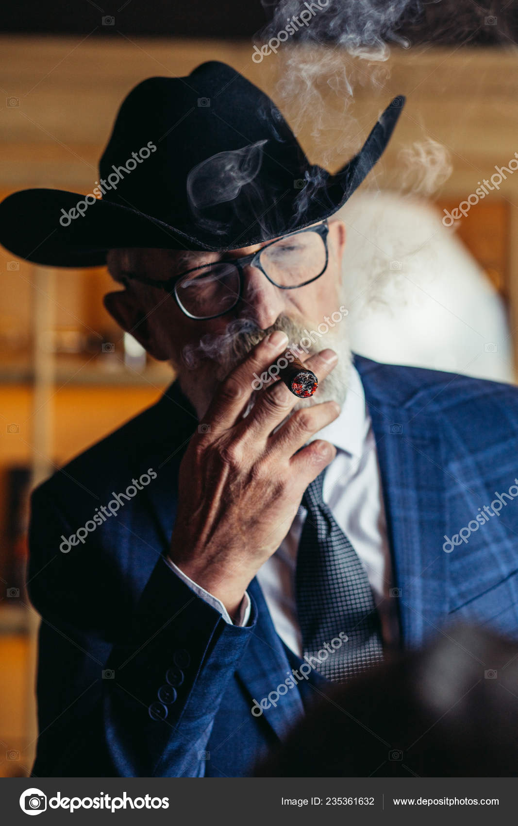 Stylish old man in wide brimmed hat and rich blue mens suit smok