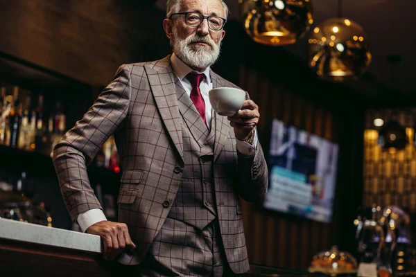 Hombre de negocios mayor beber café cerca del mostrador de bar en el descanso oscuro — Foto de Stock