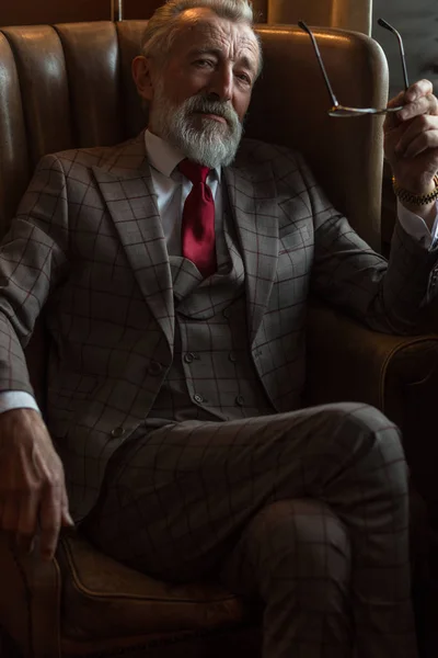 Tatmin olmuş sakallı bir emeklinin evinde dinlenirken gözlük takması.. — Stok fotoğraf