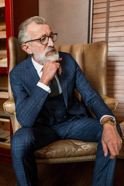 Oudere zakenman in formeel pak met whisky en sigaar in luxe interieur — Stockfoto