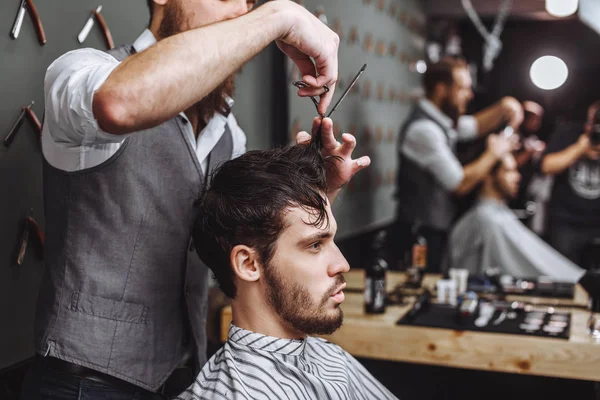 Barbiere. Un uomo con la barba nel negozio di barbiere. Moderno parrucchiere — Foto Stock