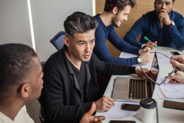 Group focused male business people gathered around computer in office talking. — Stock Photo, Image