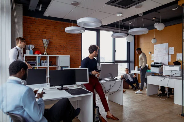 Hommes d'affaires dans un espace ouvert intérieur de bureau avec une fenêtre panoramique, plan long — Photo