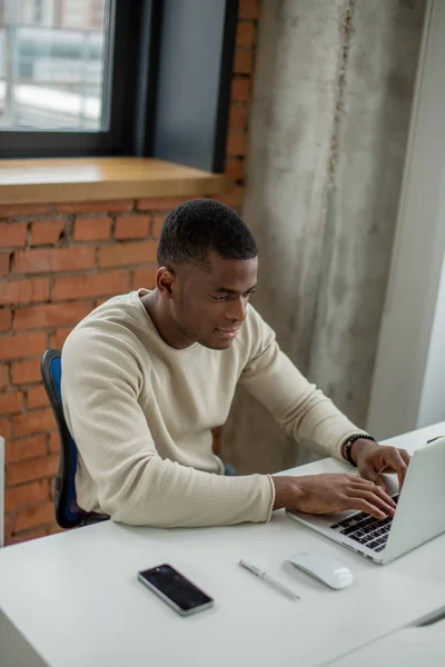 Empresário afro-americano em um terno de negócios trabalhando em laptop — Fotografia de Stock