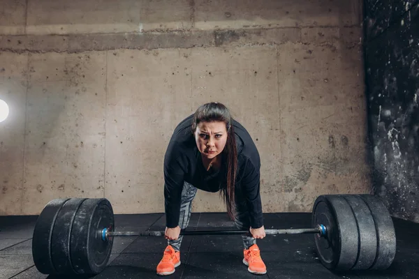 Fettes Mädchen trainiert mit großer Langhantel zum Abnehmen — Stockfoto