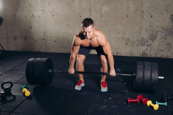 Jovem bonito abeto cara segurando enorme barbell — Fotografia de Stock