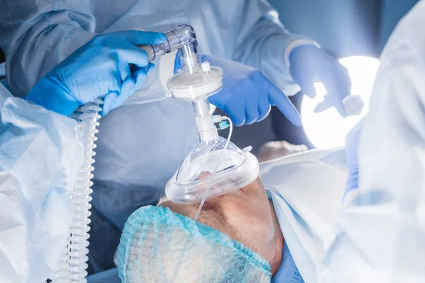 Equipo médico que realiza la operación quirúrgica en la sala de operaciones moderna brillante — Foto de Stock