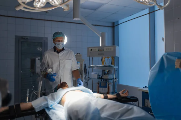 Medicinskt team utför kirurgisk operation i ljusa moderna operationssalen — Stockfoto