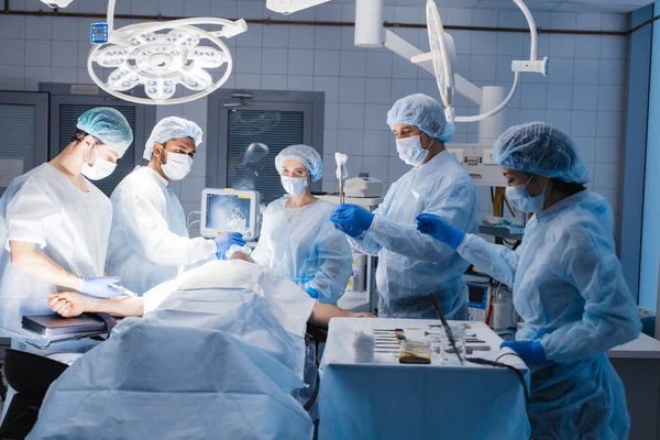 Equipo de anestesistas preparando al paciente para la cirugía en el quirófano — Foto de Stock