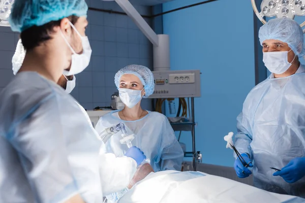 Az altatóorvosok csoportja felkészíti a beteget a műtétre a műtőben. — Stock Fotó
