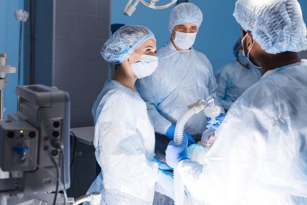 Команда анестезиологов готовит пациента к операции в операционной