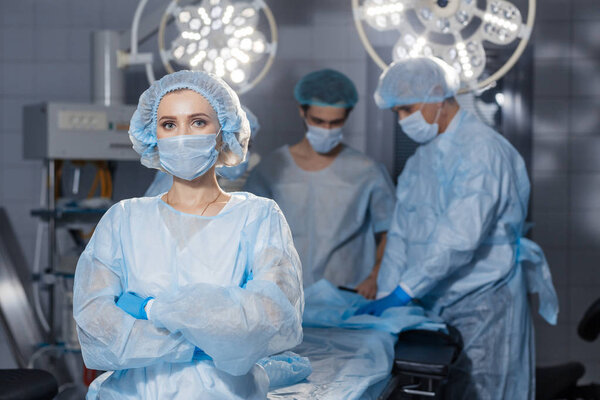 Серьезный сконцентрированный хирург в хирургической форме в операционной
.