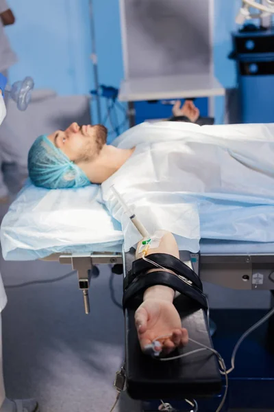 Paciente masculino con aguja de la jeringa se conecta a un catéter intravenoso — Foto de Stock