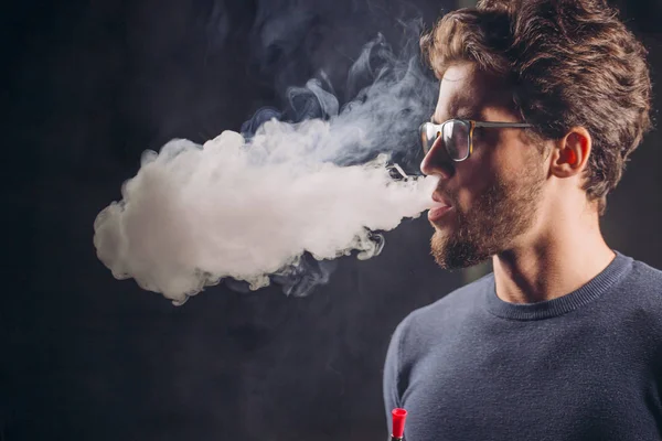 Gorgeous man breathing out smoke — Stock Photo, Image