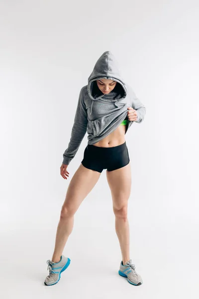 Sensual chica en forma en ropa deportiva gris está mirando hacia abajo — Foto de Stock