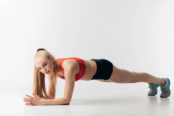 Mladá žena motivován v sportswear dělá cvičení na břišní svaly — Stock fotografie