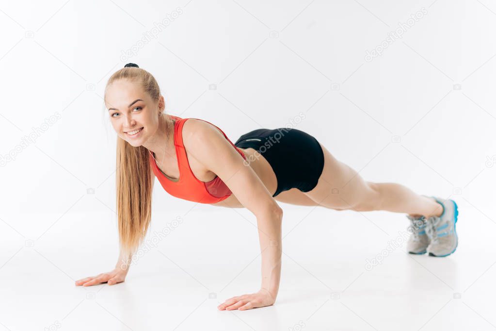 happy awesome fit girl is loking at the camera while pressing up
