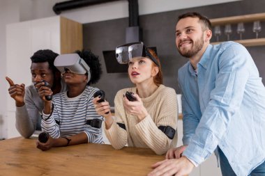 Çok kültürlü bir grup arkadaşıyla birlikte sanal gerçeklik gözlükle oyun oynamak.