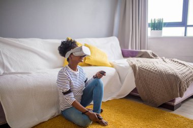 Afrikalı kadın izlerken video VR gözlükle evde uzaktan kumanda ile.