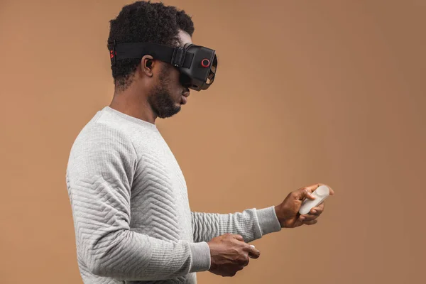 Uomo nero che indossa occhiali 3d vr, giocare a videogame, tenendo il joystick in mano — Foto Stock