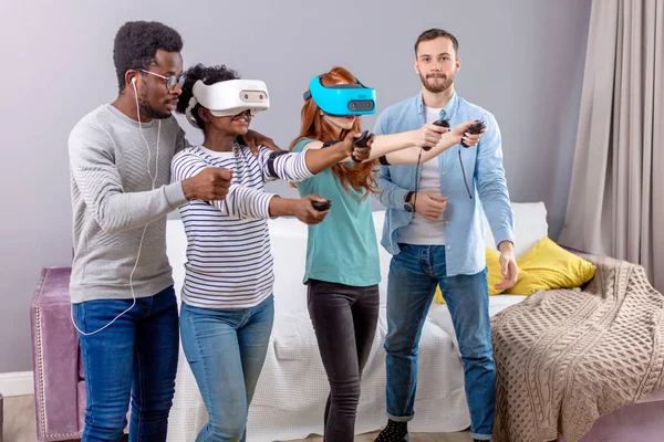 Grupo multicultural de amigos jogando jogos usando óculos de realidade virtual . — Fotografia de Stock