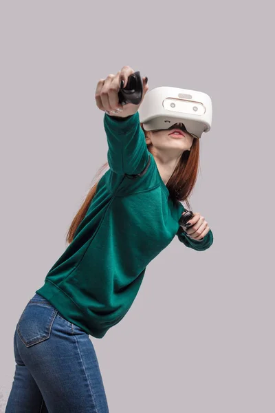 Mujer pelirroja de confianza con auriculares de realidad virtual, apuntando desde la proa —  Fotos de Stock