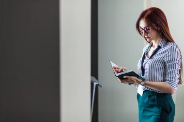 Kadın girişimci not defterinde Office notları yazarken düşünüyorum