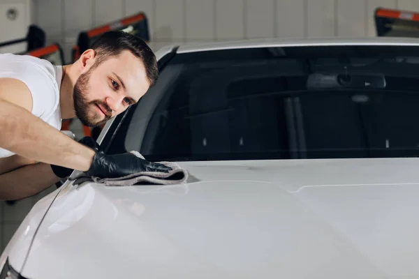 Ehrfürchtiger männlicher Angestellter mit sauberem Tuch nach dem Waschen des Autos — Stockfoto