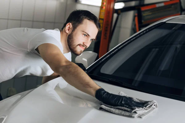 Sonriente mecánico alegre wasing y pulir una superficie del coche — Foto de Stock