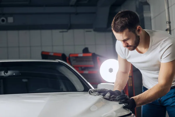 Seriózní člověk dělá jeho povrchu lesknoucí se auto — Stock fotografie