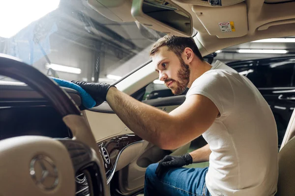 Hombre atractivo se concentra en la limpieza del coche — Foto de Stock